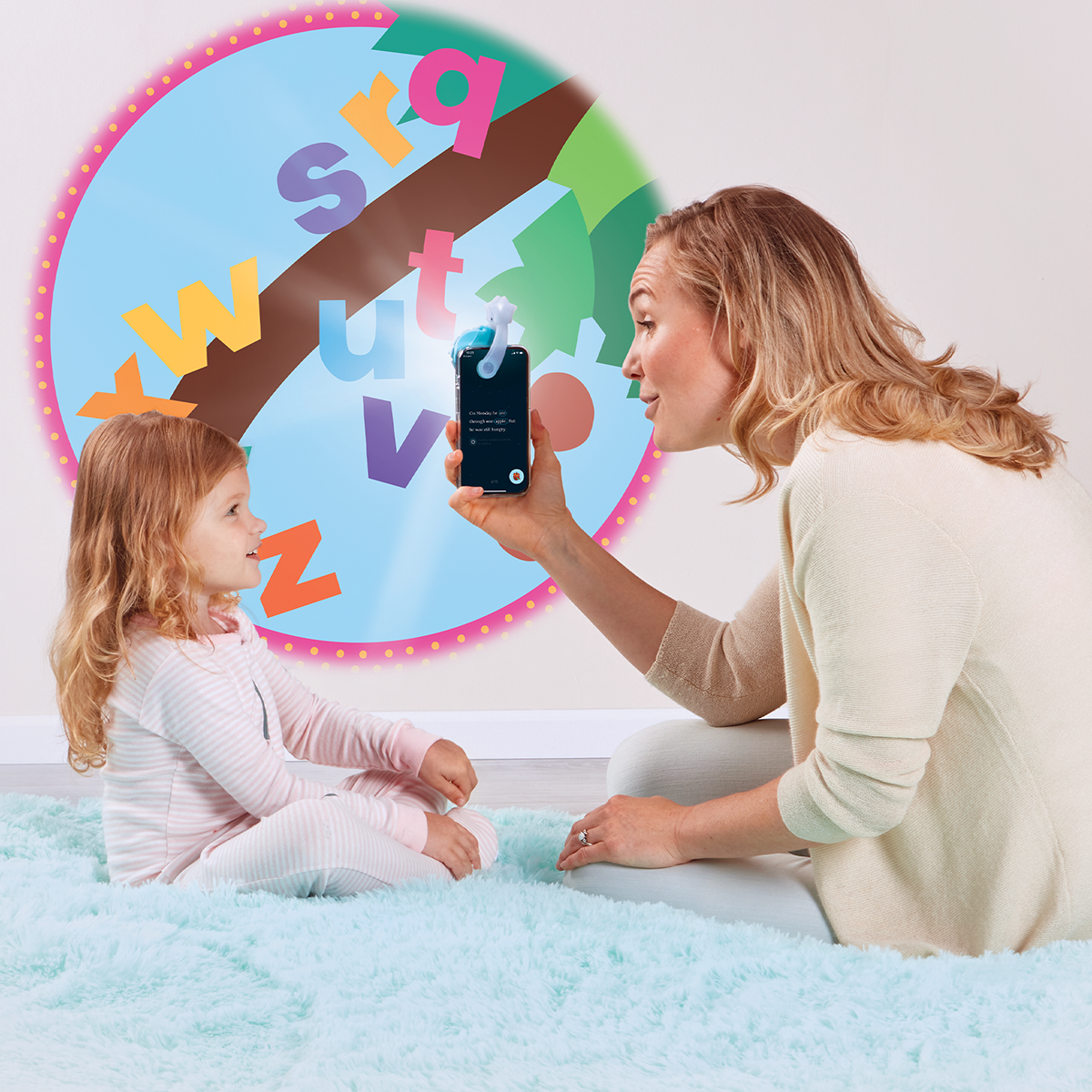 Mother reading to daughter, using the Moonlite projector to project the story images on the wall