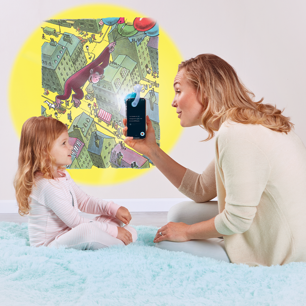 Mother reading to daughter, using the Moonlite projector to project the story images on the wall