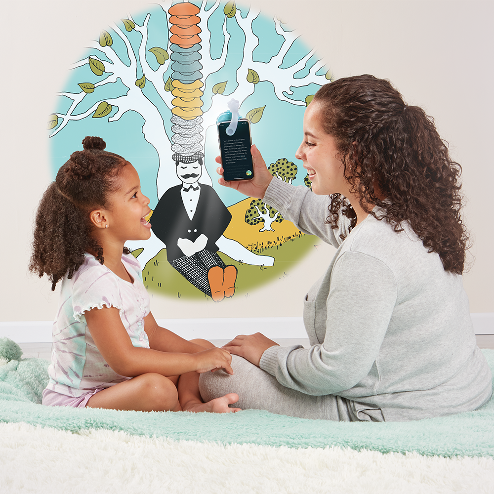 Mother reading Caps For Sale to daughter using the Moonlite Storytime Projector