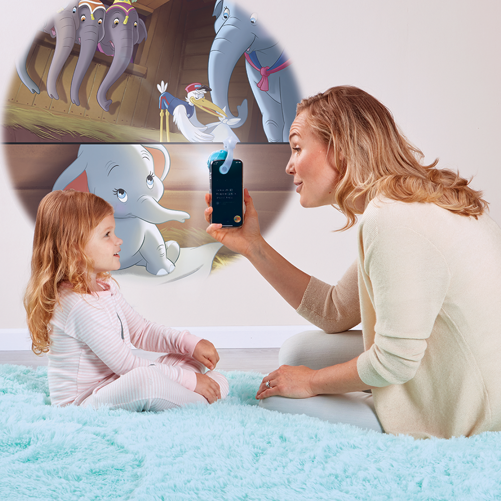 Mother reading to daughter, using the Moonlite projector to project the story images on the wall
