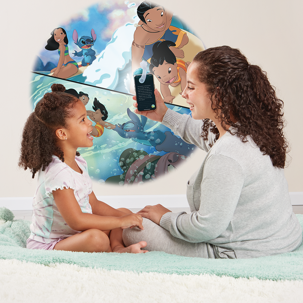 Mother reading to daughter, using the Moonlite projector to project the story images on the wall