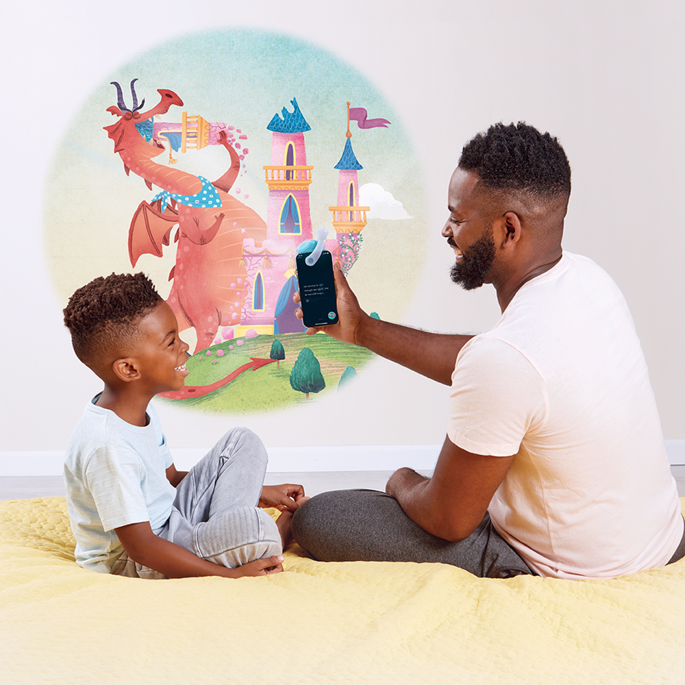 Father reading There Was an Old Dragon Who Swallowed a Knight to son using the Moonlite Storytime Projector