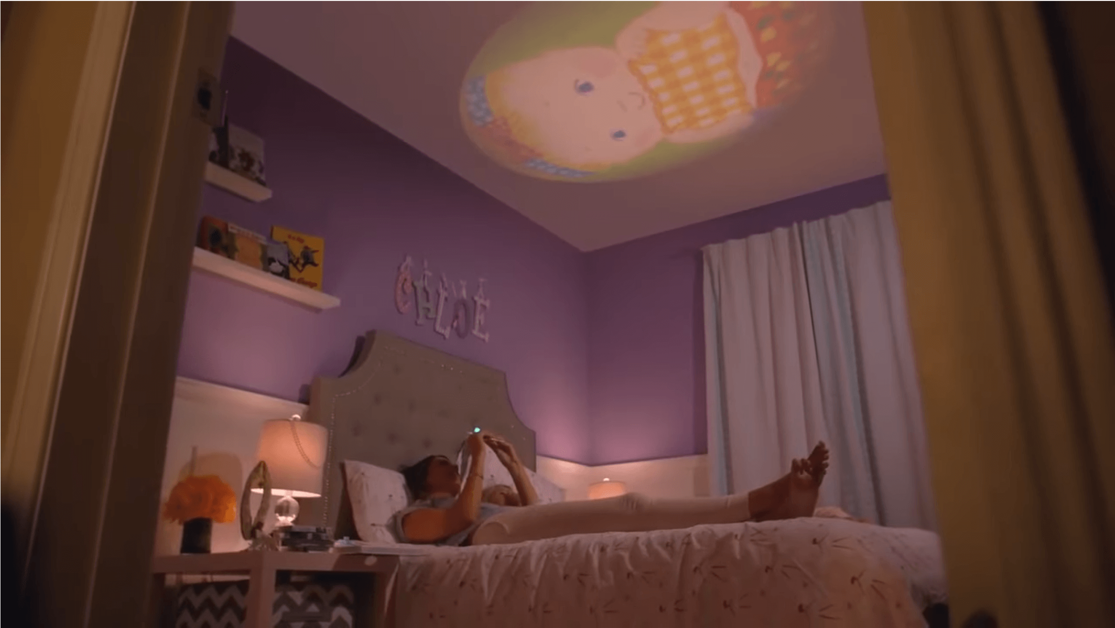 Video of a mother projecting a story book from Moonlite Collection